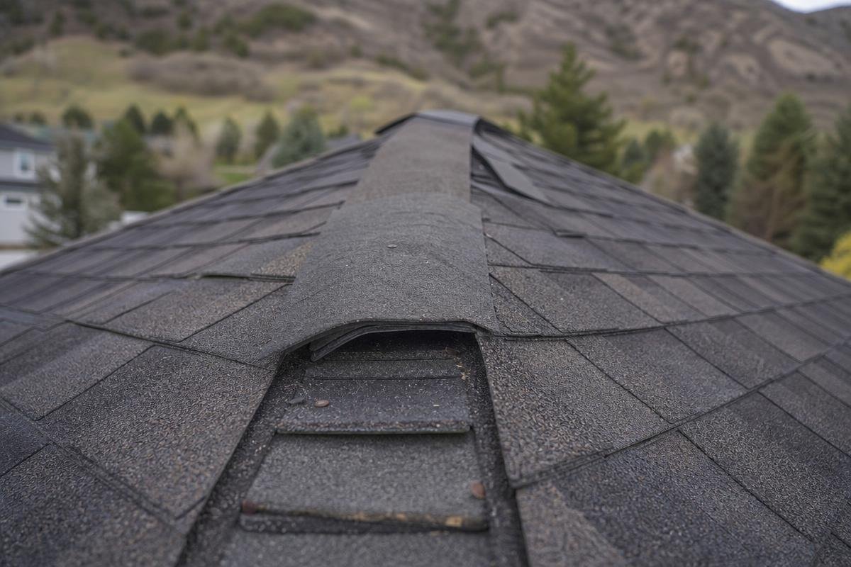 storm damage roof repair on El Dorado County home showing displaced ridge cap and lifted shingles